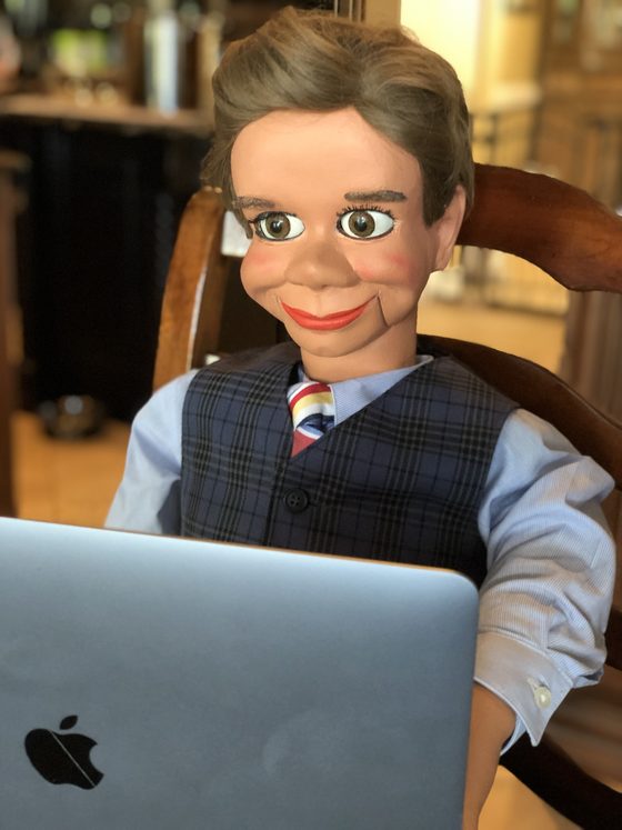Freddy Fiddlesticks, the Ventriloquism.org spokesdummy, sitting at a laptop